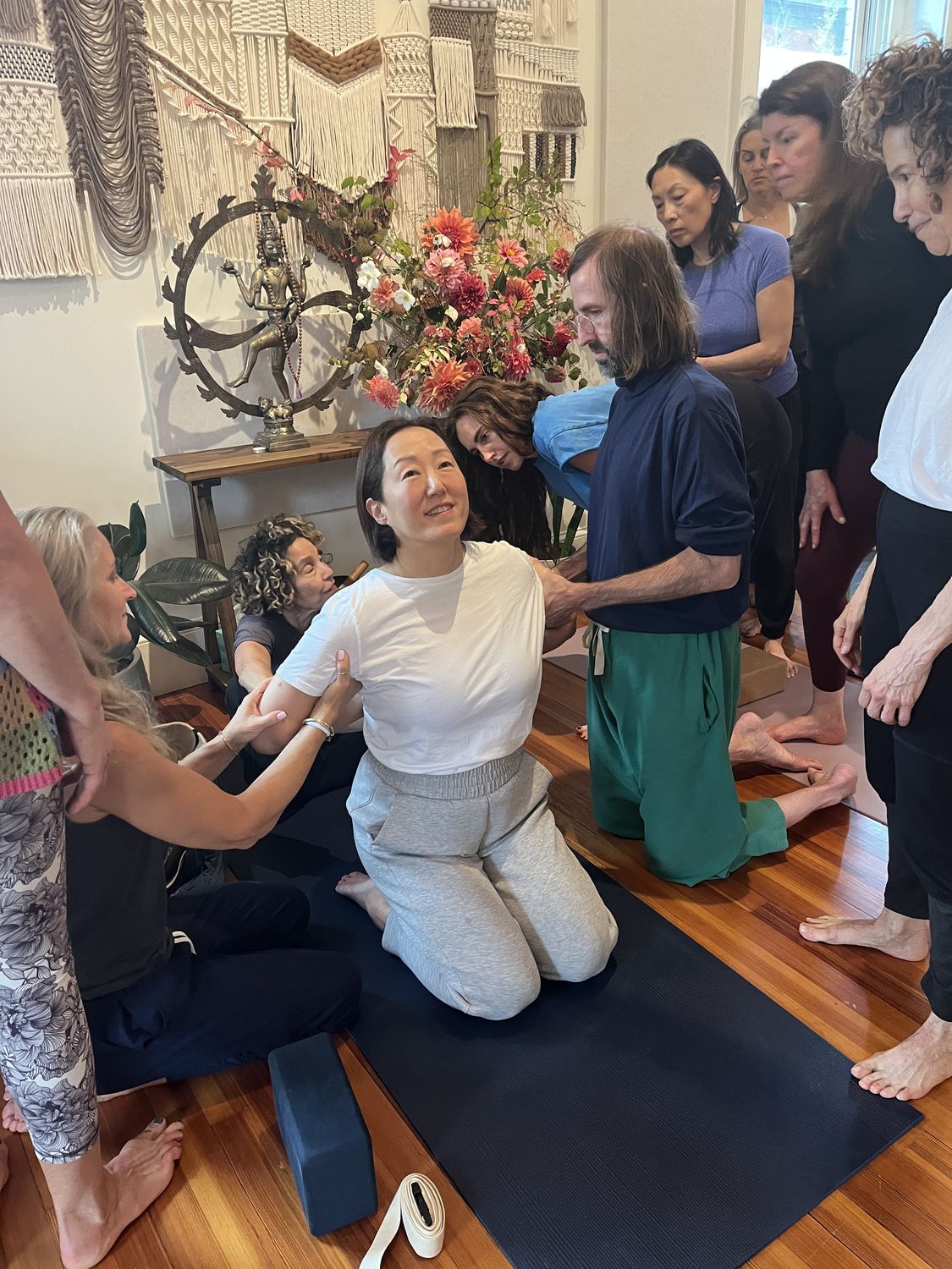 teachers gathered around a student, learning hands-on adjustments