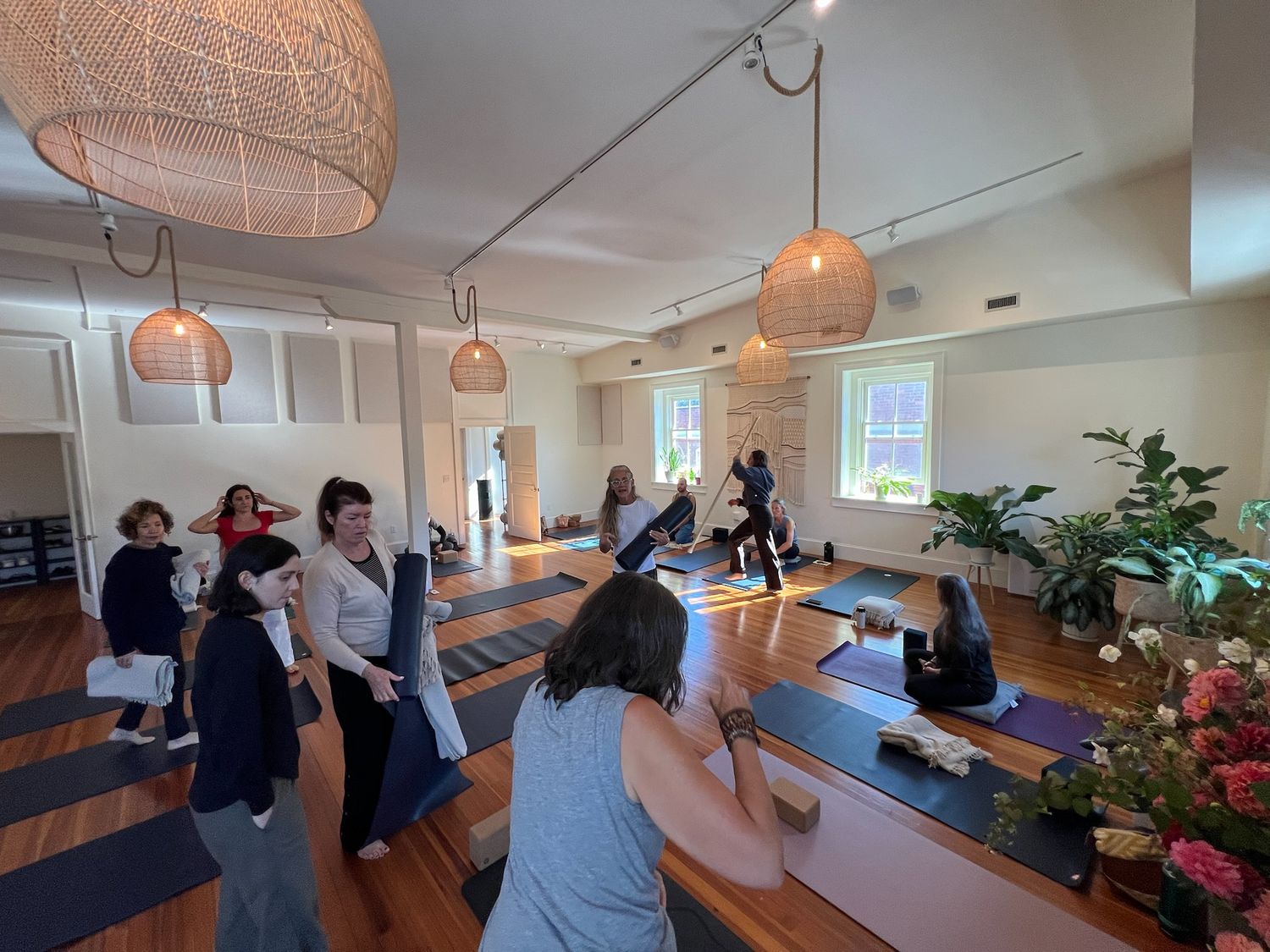 a full studio during a training weekend, under the woven pendant lights